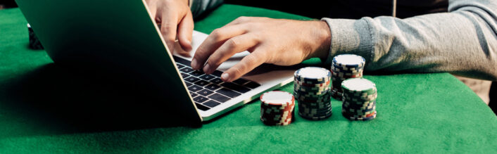 Man met laptop en pokermunten